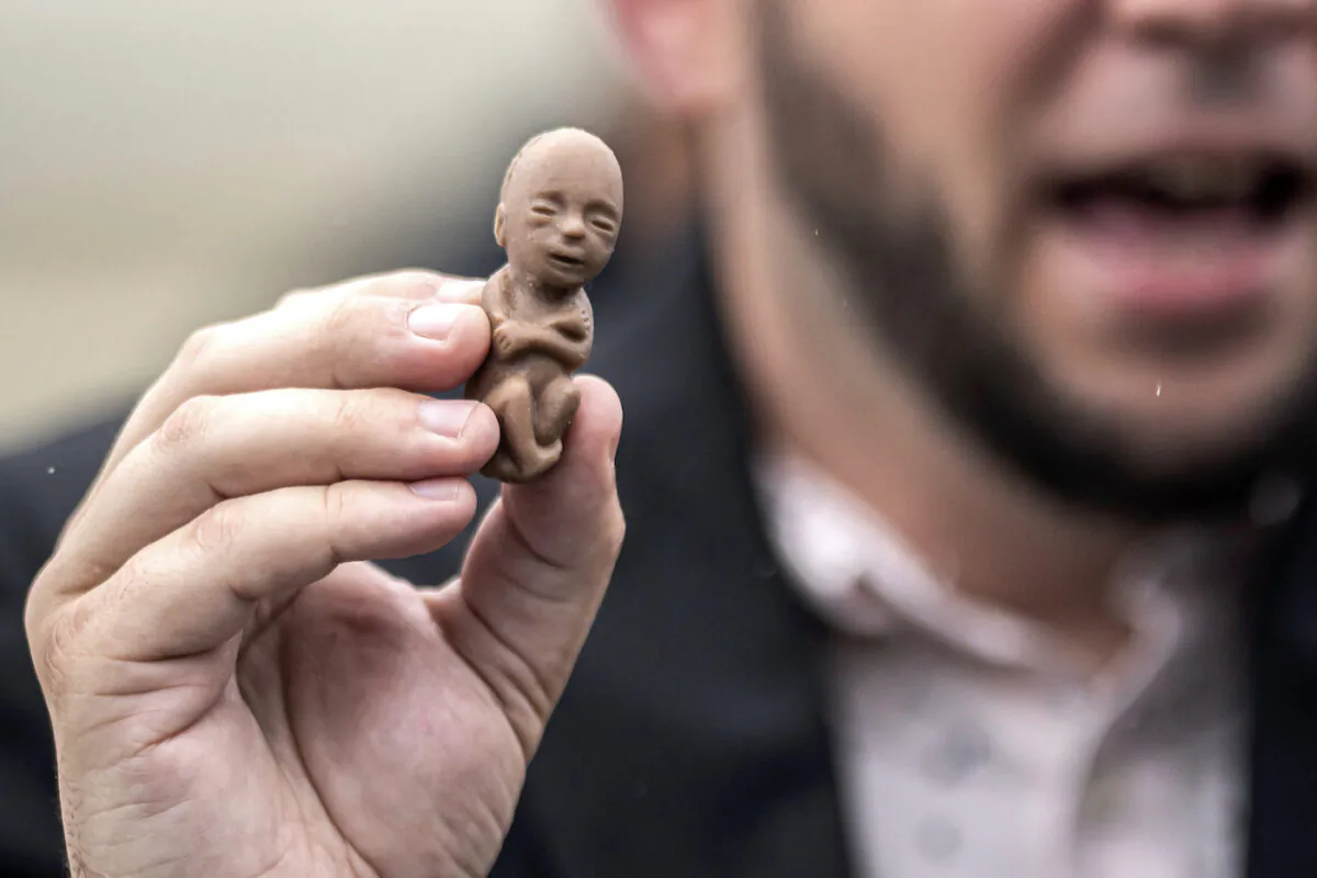 A pro-life activist holds a plastic fetus during a protest in front of the U.S. Supreme Court in Washington on June 23, 2022. (Nathan Howard/Getty Images)