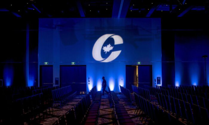 A man is silhouetted walking past a Conservative Party logo before the opening of the Party's national convention in Halifax on Aug. 23, 2018. (The Canadian Press/Darren Calabrese)