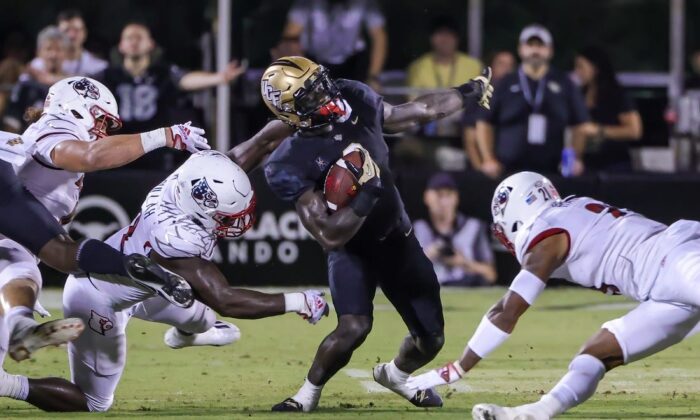 UCF Knights running back Jordan McDonald (9) is tackled by Louisville Cardinals linebacker Yasir Abdullah (22) during the second quarter at FBC Mortgage Stadium in Orlando, Flor., on Sept. 9, 2022. (Mike Watters/USA TODAY Sports via Field Level Media)