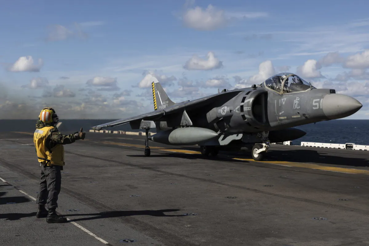 Final checker gives a thumb up to an AV-8B Harrier taking off from the flight deck of the Wasp-class amphibious assault ship USS Kearsarge (LHD 3), operating in the Baltic Sea on Sept. 3, 2022. (Michal Dyjuk/AP Photo)