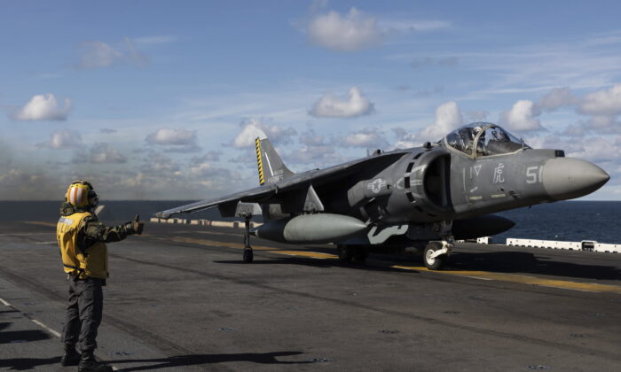 Final checker gives a thumb up to an AV-8B Harrier taking off from the flight deck of the Wasp-class amphibious assault ship USS Kearsarge (LHD 3), operating in the Baltic Sea on Sept. 3, 2022. (Michal Dyjuk/AP Photo)