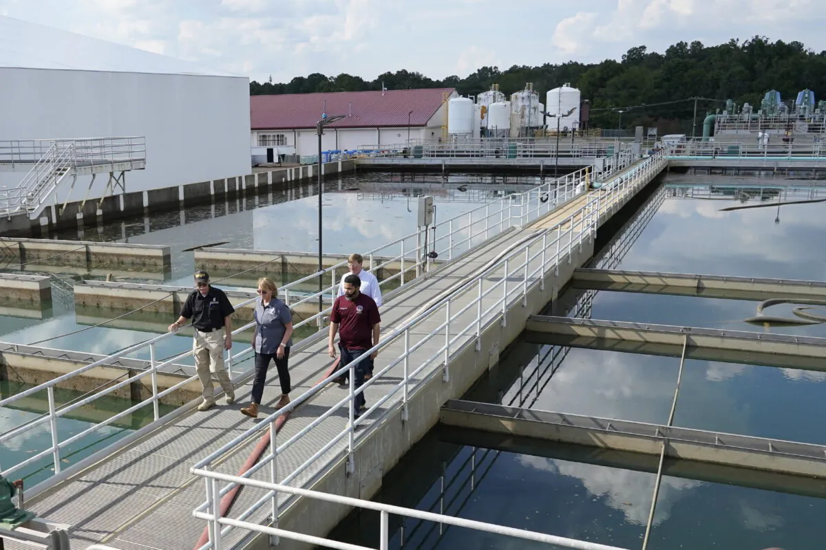 Jim Craig, with the Mississippi State Department of Health, left, leads Jackson Mayor Chokwe Antar Lumumba, right, Deanne Criswell, administrator of the Federal Emergency Management Agency (FEMA), center, and Mississippi Gov. Tate Reeves, rear, as they walk past sedimentation basins at the City of Jackson's O.B. Curtis Water Treatment Facility in Ridgeland, Miss., on Sept. 2, 2022. (Rogelio V. Solis/AP Photo, Pool)