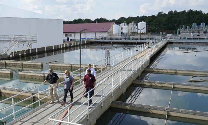 Jim Craig, with the Mississippi State Department of Health, left, leads Jackson Mayor Chokwe Antar Lumumba, right, Deanne Criswell, administrator of the Federal Emergency Management Agency (FEMA), center, and Mississippi Gov. Tate Reeves, rear, as they walk past sedimentation basins at the City of Jackson's O.B. Curtis Water Treatment Facility in Ridgeland, Miss., on Sept. 2, 2022. (Rogelio V. Solis/AP Photo, Pool)