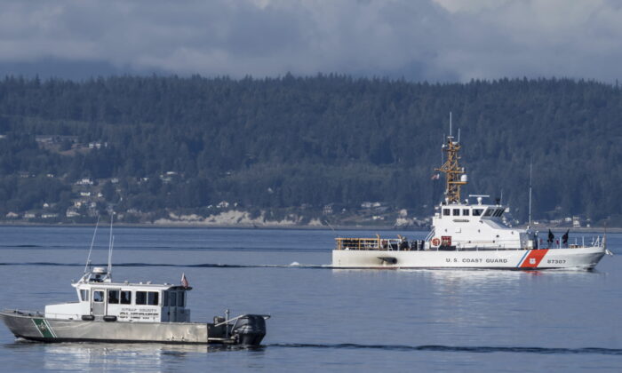 A U.S. Coast Guard boat and Kitsap, Wash., County Sherrif boat search the area  near Freeland, Wash., off Whidbey Island north of Seattle, on Sept. 5, 2022. (Stephen Brashear/AP Photo)