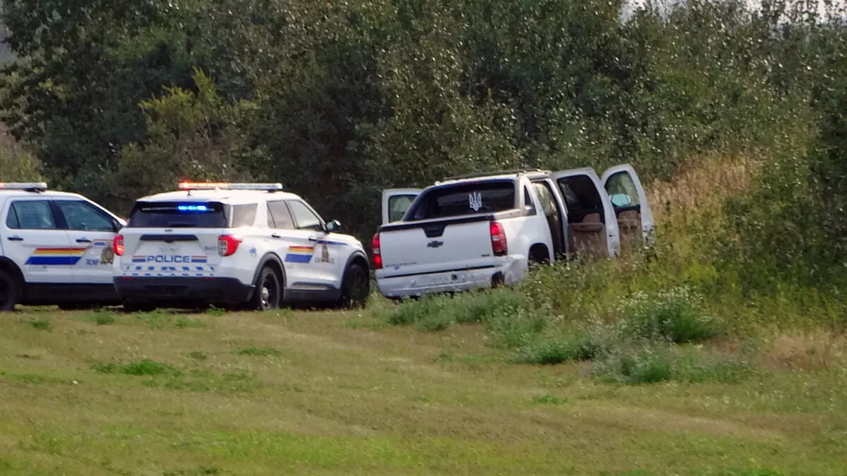 Police and investigators are seen at the side of the road outside Rosthern, Saskatchewan on Sept. 7, 2022.  (The Canadian Press/Kelly Geraldine Malone)
