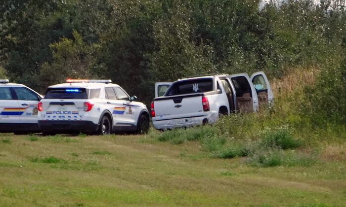 Police and investigators are seen at the side of the road outside Rosthern, Saskatchewan on Sept. 7, 2022.  (The Canadian Press/Kelly Geraldine Malone)