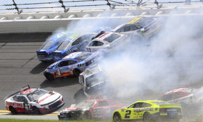 Chris Buescher (17), Daniel Suarez (99), Denny Hamlin (11), Justin Haley (31), Kevin Harvick (4), Ty Dillon (42), Aric Almirola (10) and others are involved in a multi-car accident between turns 1 and 2 during a NASCAR Cup Series auto race at Daytona International Speedway in Daytona Beach, Fla., on Aug. 28, 2022. (Dow Graham/AP Photo)