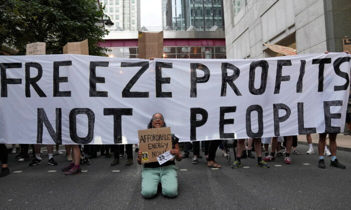 2022 年 8 月 26 日，在英国伦敦宣布能源价格上限后，示威者在 Ofgem 总部外的抗议活动中封锁了金丝雀码头的一条街道。（Maja Smiejkowska/路透社）