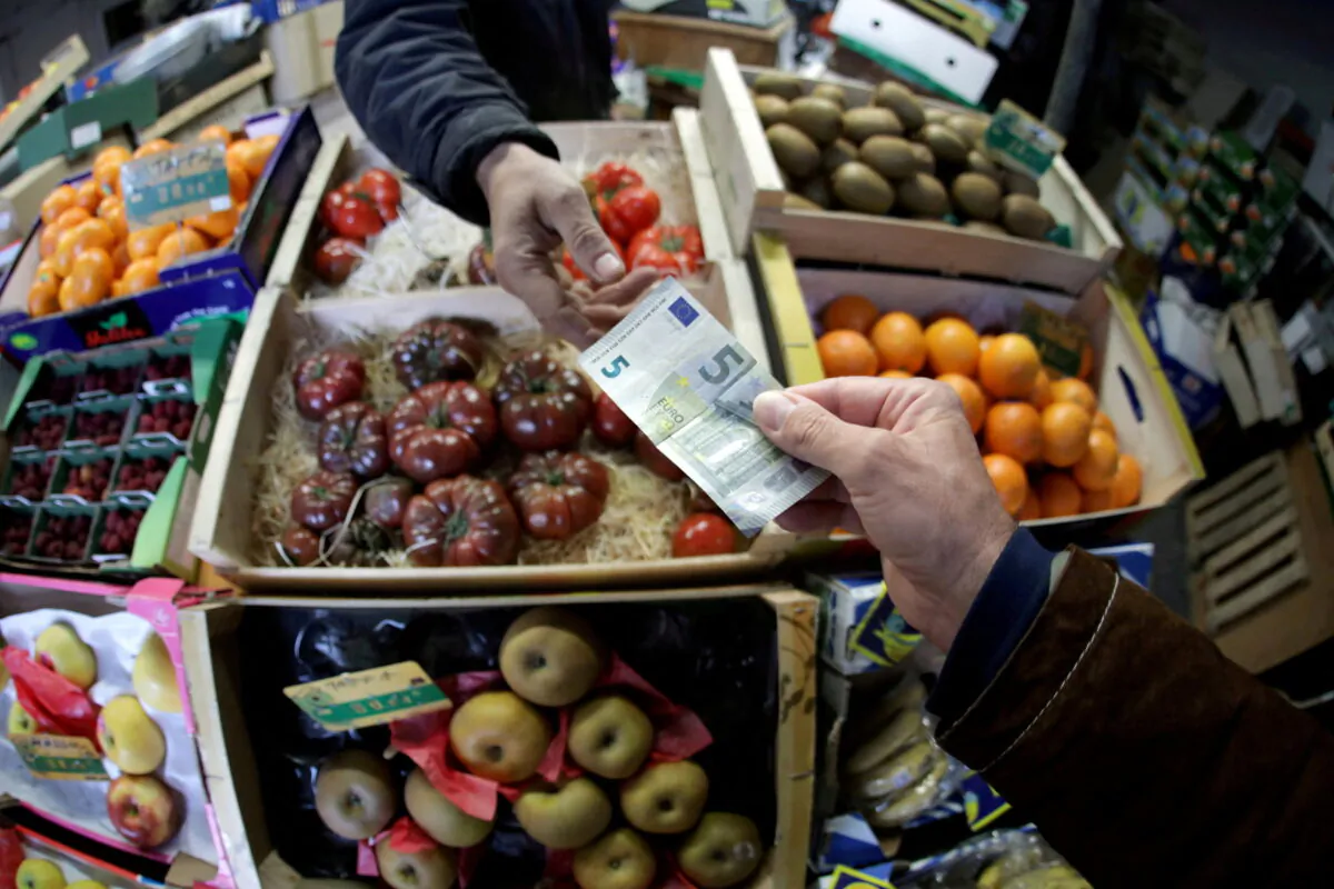 A shopper pays with a euro bank note in a market in Nice, France, on April 3, 2019. (Eric Gaillard/Reuters)
