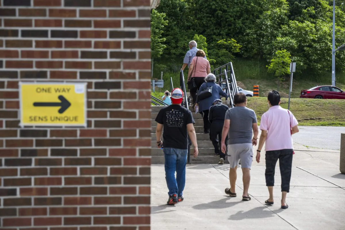 Voters head to cast their vote in the Ontario provincial election at a polling station in Woodbridge, Ont., on June 2, 2022. (The Canadian Press/Aaron Vincent Elkaim)