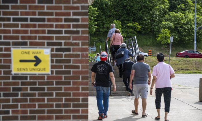Voters head to cast their vote in the Ontario provincial election at a polling station in Woodbridge, Ont., on June 2, 2022. (The Canadian Press/Aaron Vincent Elkaim)