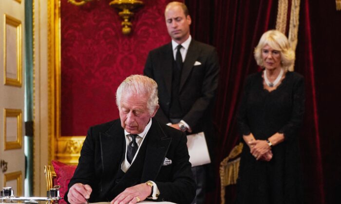 Britain's Prince William, Prince of Wales (C) and Camilla, Queen Consort (R) watch as King Charles III signs an oath to uphold the security of the Church in Scotland, during a meeting of the Accession Council inside St James's Palace in London on Sept. 10, 2022. (Victoria Jones/Pppl/AFP via Getty Images)
