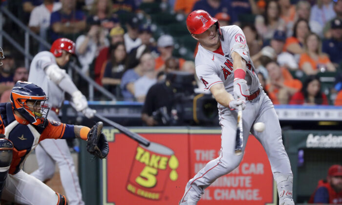 Los Angeles Angels' Mike Trout, right, connects for a two-un home run in front of Houston Astros catcher Martin Maldonado, left, during the sixth inning of a baseball game in Houston, Sept. 9, 2022. (Michael Wyke/AP Photo)