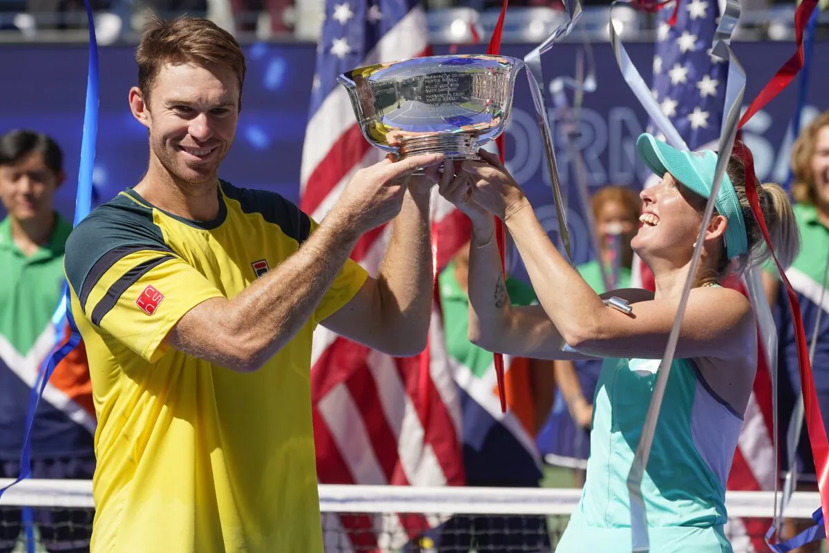 John Peers (L) and Storm Sanders of Australia hold up the championship trophy after winning the mixed doubles final against Kirsten Flipkens of Belgium, and Edouard Roger-Vasselin of France at the U.S. Open tennis championships in New York, on Sept. 10, 2022. (Matt Rourke/AP Photo)