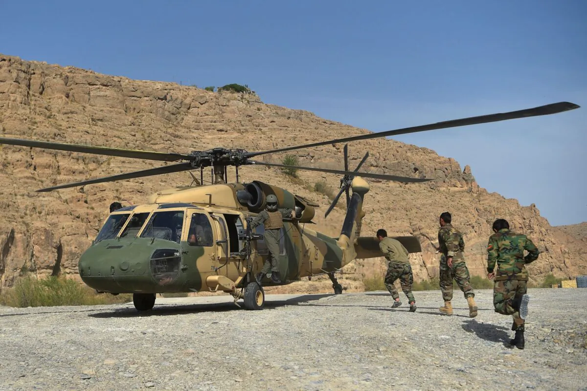 Afghan National Army (ANA) soldiers unload food items and petrol oil from an Afghan Air Force Black Hawk helicopter at the hydroelectric Kajaki Dam in Kajaki, northeast of Helmand Province on March 25, 2021. (Wakil Kohsar/AFP via Getty Images)