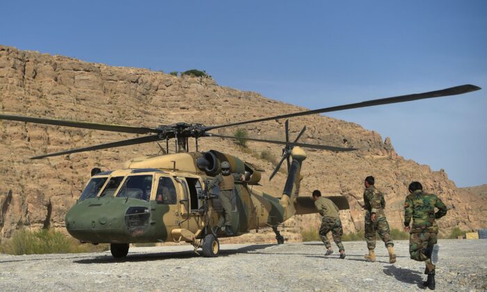 Afghan National Army (ANA) soldiers unload food items and petrol oil from an Afghan Air Force Black Hawk helicopter at the hydroelectric Kajaki Dam in Kajaki, northeast of Helmand Province on March 25, 2021. (Wakil Kohsar/AFP via Getty Images)