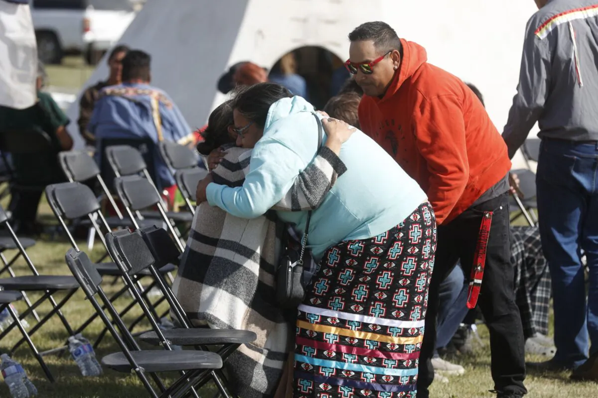 People hug before a press conference by officials at the James Smith Cree Nation on Sept. 8, 2022. (Lars Hagberg/AFP via Getty Images)