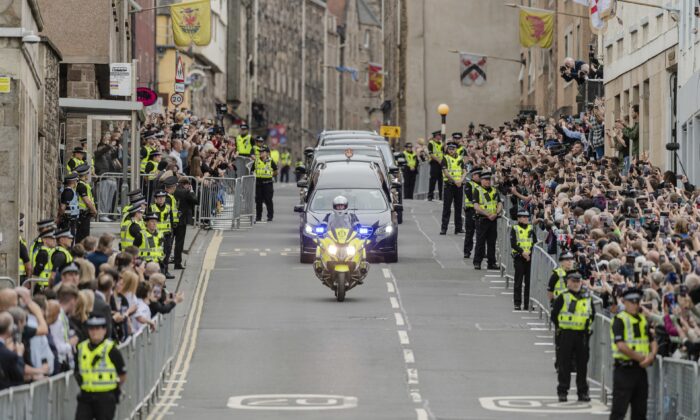 The hearse carrying the coffin of Queen Elizabeth II, draped with the Royal Standard of Scotland, passing along the Royal Mile, Edinburgh, on Sept. 11, 2022. (Euan Cherry/Scottish Daily Mail via PA Media)

