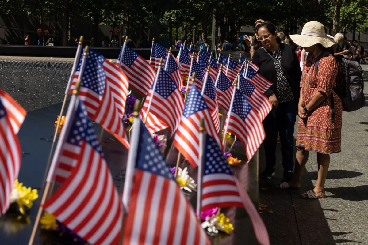 Visitors look at U.S. flags on the 9/11 Memorial in New York, on Sept. 10, 2022, one day before the 21st anniversary of the attacks on the World Trade Center, Pentagon, and Shanksville, Pennsylvania. (Yuki Iwamuri/AFP via Getty Images)