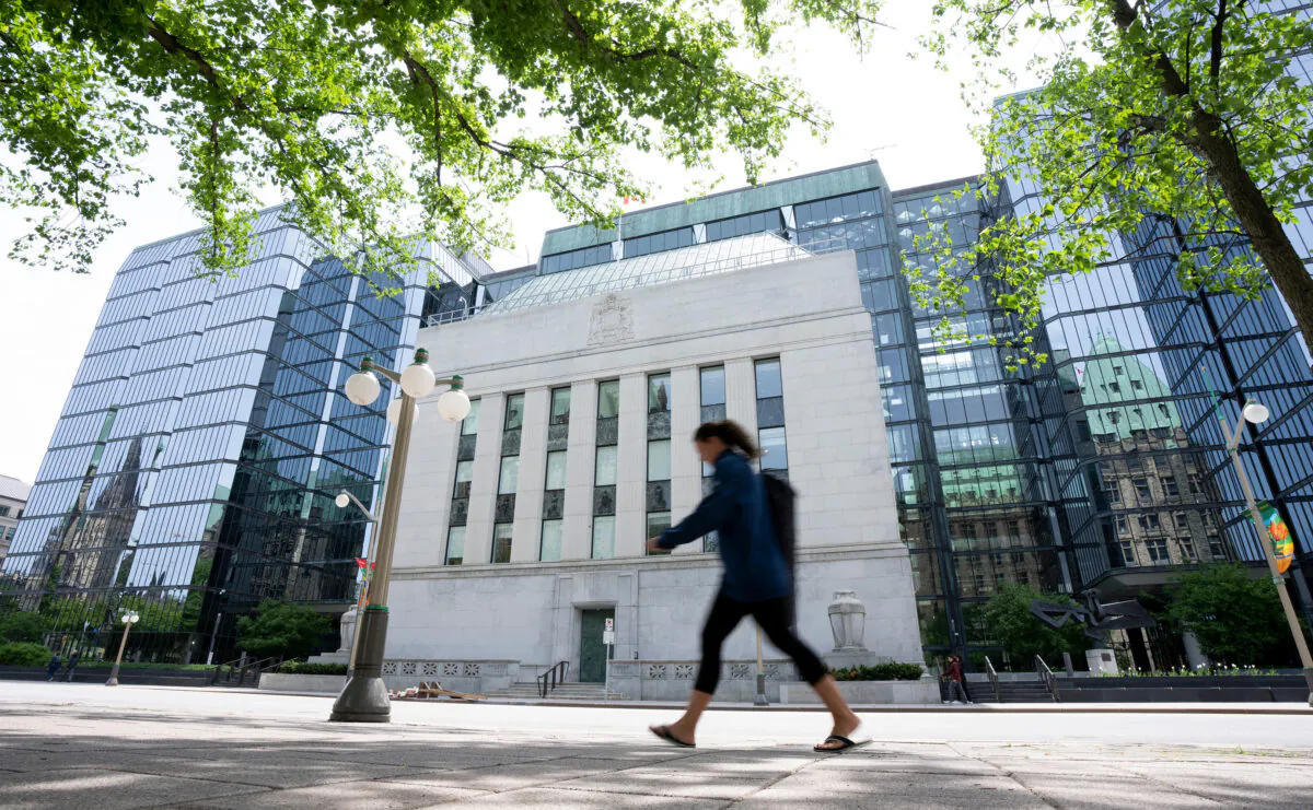 A woman walks past the Bank of Canada headquarters in Ottawa on June 1, 2022. (THE CANADIAN PRESS/Adrian Wyld)