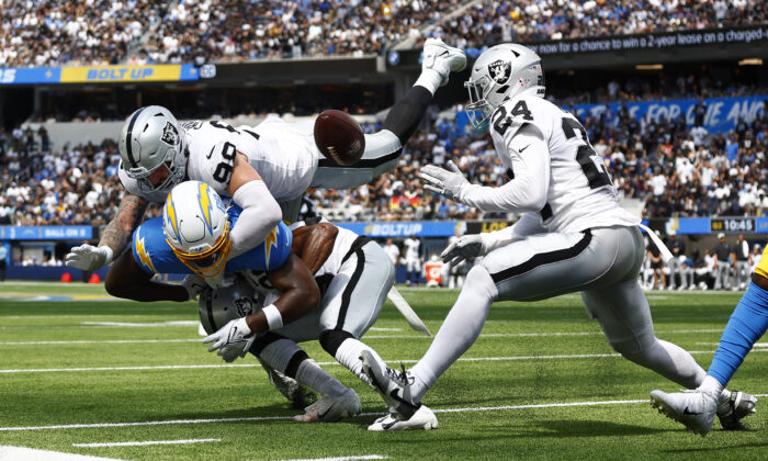 Tight end Tre' McKitty (88) of the Los Angeles Chargers fails to catch a pass while being hit by cornerback Nate Hobbs (39) of the Las Vegas Raiders defensive end Maxx Crosby (98) of the Las Vegas Raiders, and safety Johnathan Abram (24) of the Las Vegas Raiders at SoFi Stadium in Inglewood, Calif., on Sept. 11, 2022. (Ronald Martinez/Getty Images)
