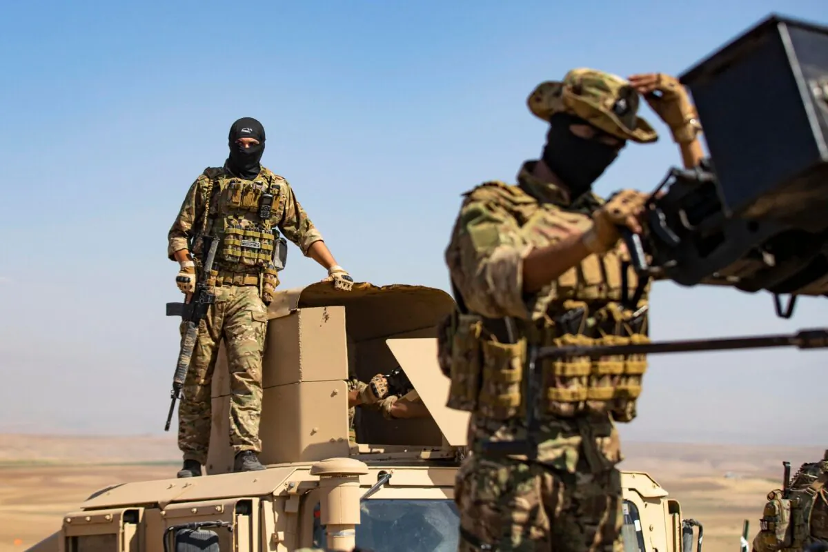 A fighter of the Syrian Democratic Forces (SDF) stands atop a Humvee during a joint military exercise with forces of the U.S.-led "Combined Joint Task Force-Operation Inherent Resolve" coalition against the ISIS group in the countryside of the town of al-Malikiya (Derik in Kurdish) in Syria's northeastern Hasakah province on Sept. 7, 2022. (Delil Souleiman/AFP via Getty Images)
