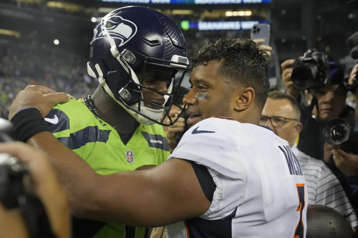Seattle Seahawks quarterback Geno Smith, left, talks with Denver Broncos quarterback Russell Wilson, right, after an NFL football game in Seattle, Sept. 12, 2022. (Stephen Brashear/AP Photo)