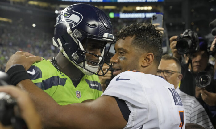 Seattle Seahawks quarterback Geno Smith, left, talks with Denver Broncos quarterback Russell Wilson, right, after an NFL football game in Seattle, Sept. 12, 2022. (Stephen Brashear/AP Photo)