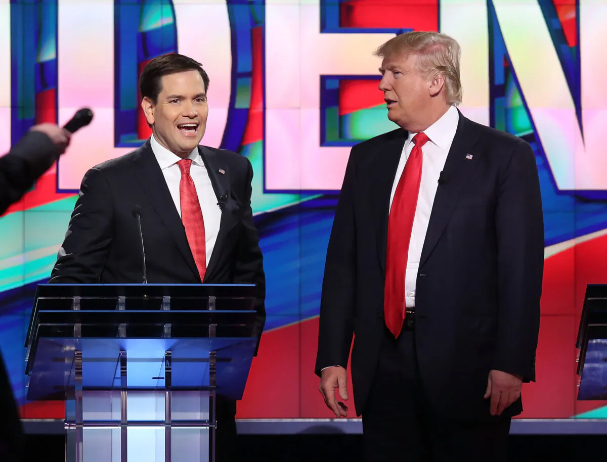 (L—R) Sen. Marco Rubio (R-Fla.) and former President Donald Trump, who were then-Republican presidential candidates, chat during a commercial break in the broadcast of a presidential primary debate at the University of Miami in Coral Gables, Fla., on March 10, 2016. (Joe Raedle/Getty Images)