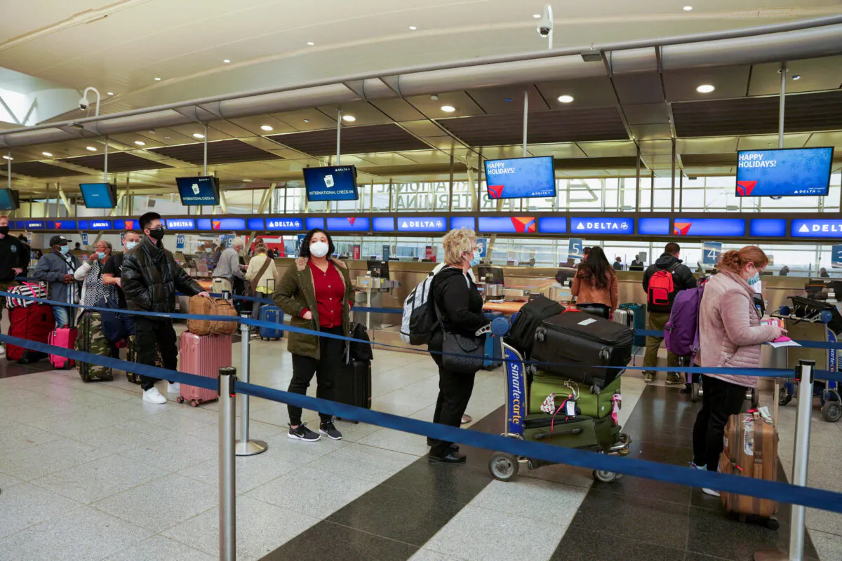 Passengers line up at John F. Kennedy International Airport after airlines announced numerous flights were canceled during the spread of the Omicron COVID-19 variant in Queens, New York, on Dec. 24, 2021, Christmas Eve. (Dieu-Nalio Chery/Reuters)