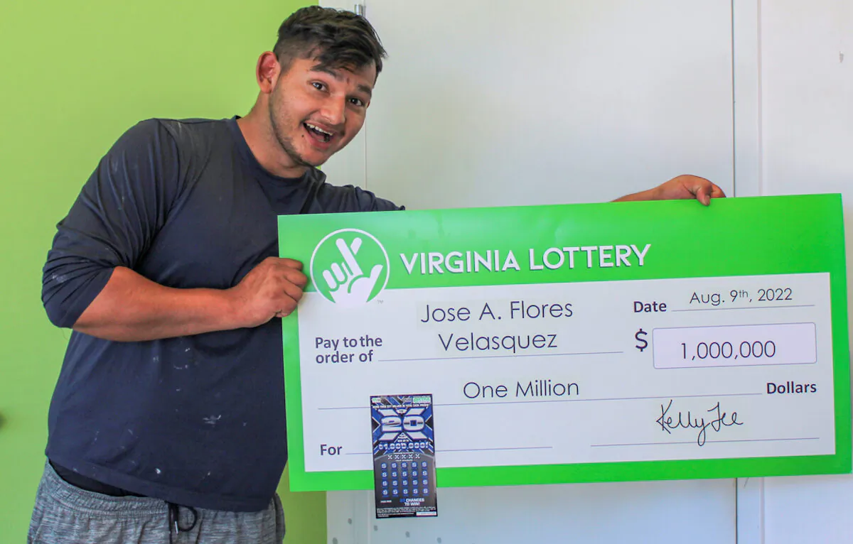 Jose Flores Velasquez holds a check of $1 million after winning that amount from the Virginia Lottery. (Courtesy of Virginia Lottery)