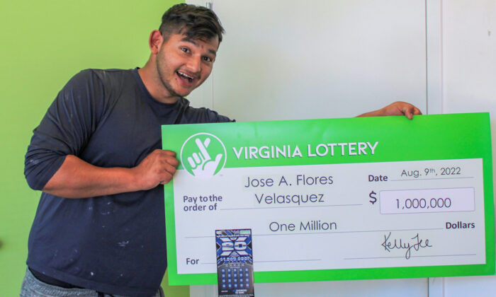 Jose Flores Velasquez holds a check of $1 million after winning that amount from the Virginia Lottery. (Courtesy of Virginia Lottery)