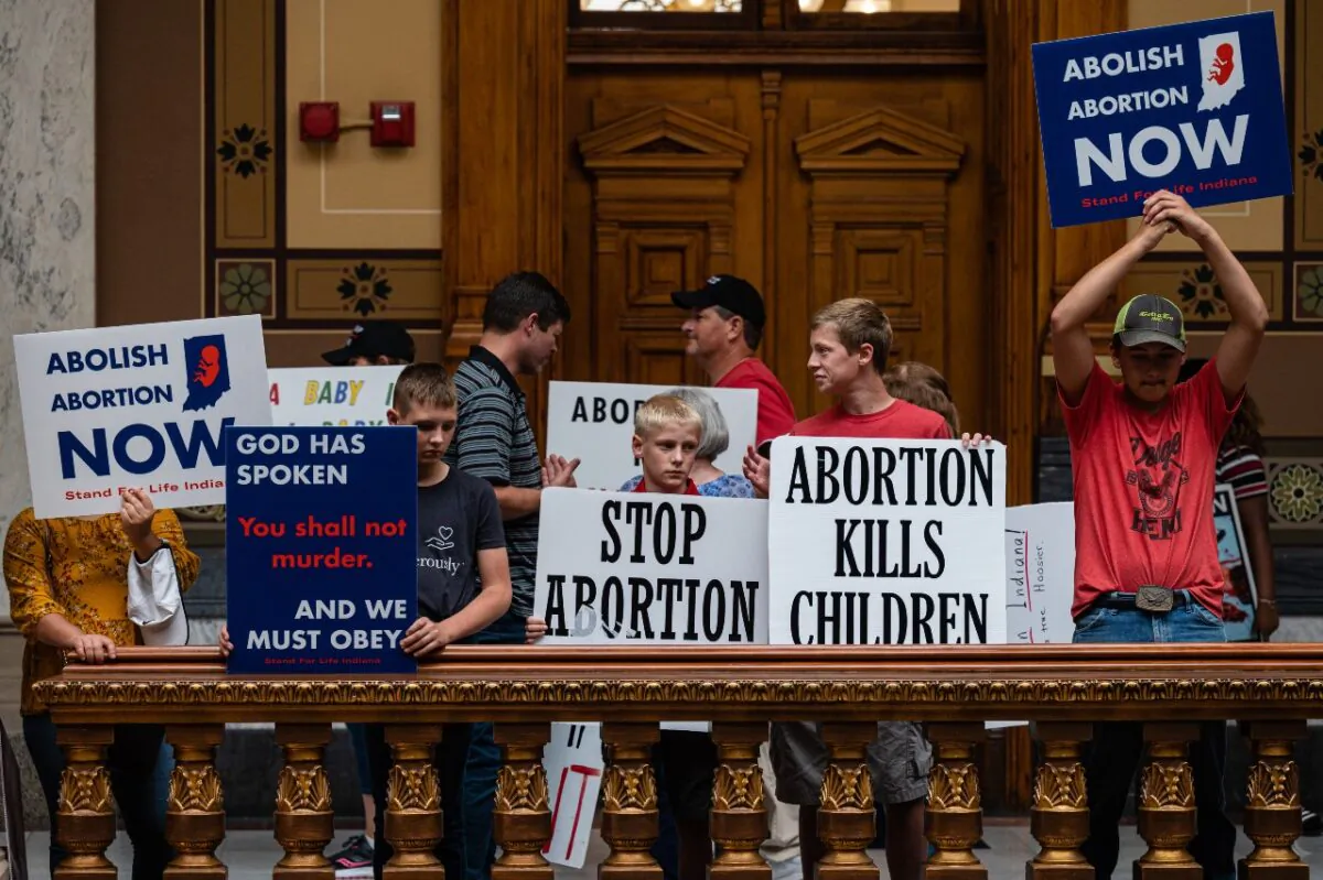 Pro-life protesters hold up signs inside  the Indiana State Capitol building in Indianapolis on July 25, 2022. (Jon Cherry/Getty Images)
