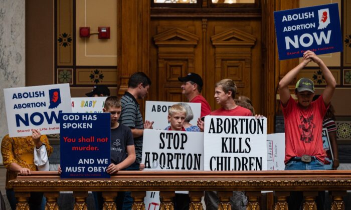 Pro-life protesters hold up signs inside  the Indiana State Capitol building in Indianapolis on July 25, 2022. (Jon Cherry/Getty Images)