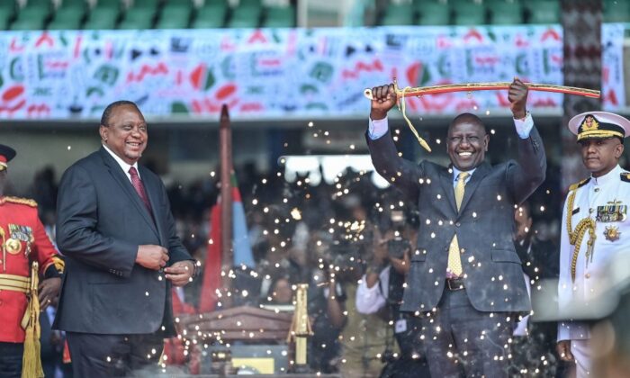 Outgoing Kenya President Uhuru Kenyatta looks on as President William Ruto lifts a sword during the inauguration ceremony at the Moi International Sports Center Kasarani in Nairobi, Kenya, on Sept. 13, 2022. (Tony Karumba/AFP via Getty Images)