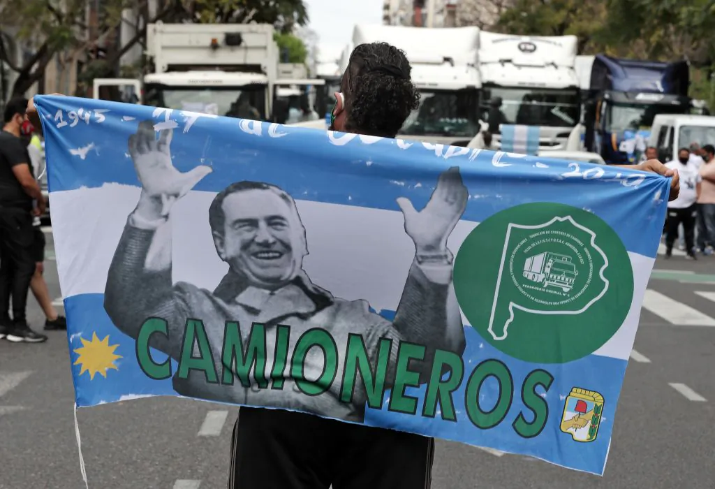 A demonstrator holds a flag depicting late Argentine president Juan Domingo Peron as he takes part in a march in support of the government on Loyalty Day, which this year commemorates the 75th anniversary of the birth of Peronism, in Buenos Aires, Argentina, on Oct. 17, 2020 (Alejandro Pagni/AFP via Getty Images)