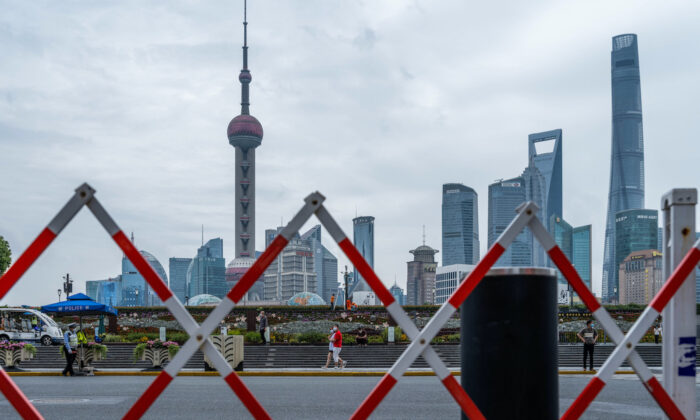 Pedestrians walk on the Bund, opposite Lujiazui Financial Center in Shanghai on June 10, 2022, amid preparations for city wide COVID-19 testing. (Liu Jin/AFP via Getty Images)