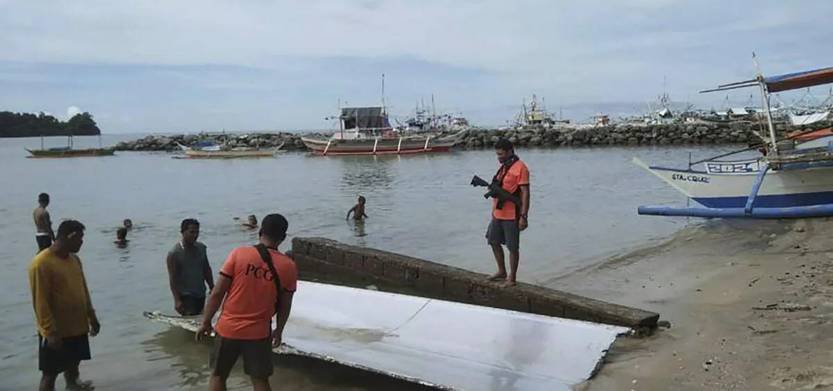 Philippine Coast Guard personnel inspect debris, which the Philippine Space Agency said has markings of the Long March 5B (CZ-5B) Chinese rocket that was launched on July 24, 2022 after it was found in waters off Mamburao, Occidental Mindoro province, Philippines, on Aug. 2, 2022, in a handout photo. (Philippine Coast Guard via AP)
