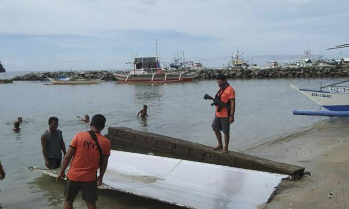 Philippine Coast Guard personnel inspect debris, which the Philippine Space Agency said has markings of the Long March 5B (CZ-5B) Chinese rocket that was launched on July 24, 2022 after it was found in waters off Mamburao, Occidental Mindoro province, Philippines, on Aug. 2, 2022, in a handout photo. (Philippine Coast Guard via AP)