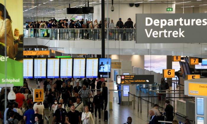 Travellers wait in long lines to check in and board flights at Amsterdam's Schiphol Airport on June 21, 2022. (Peter Dejong/AP Photo)