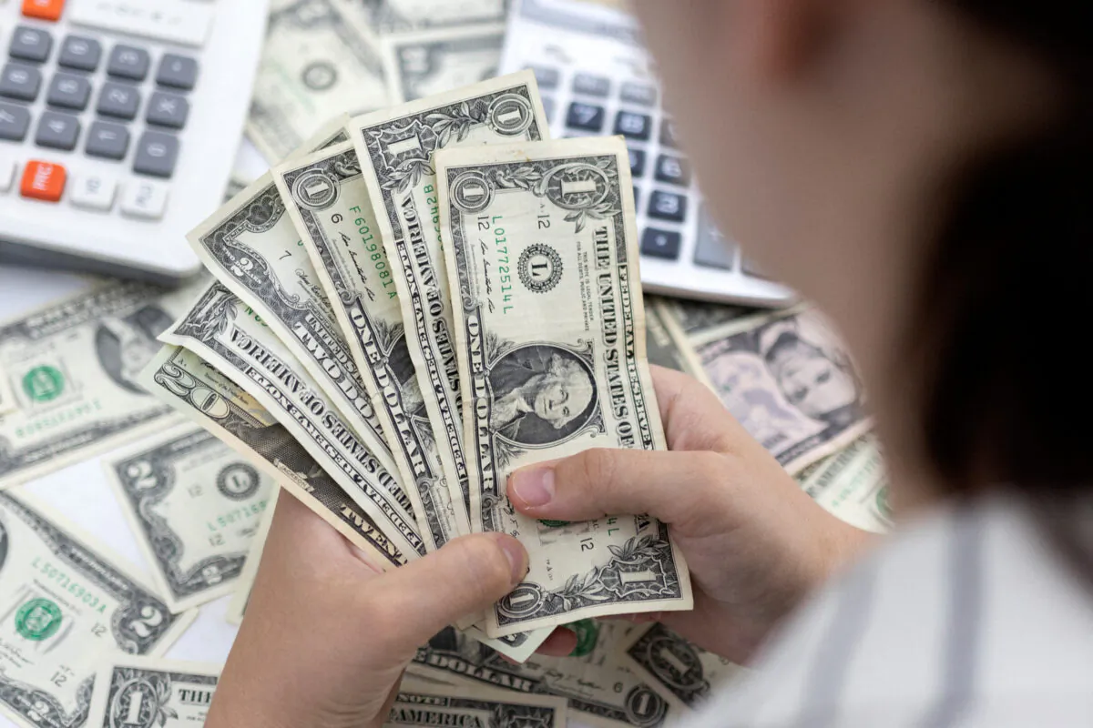 A woman holds U.S. dollar banknotes on May 30, 2022. (Dado Ruvic/Illustration/Reuters)