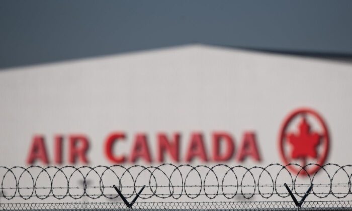 An Air Canada hangar is seen behind a security fence at Vancouver International Airport, in Richmond, B.C., on March 20, 2020. (The Canadian Press/Darryl Dyck)