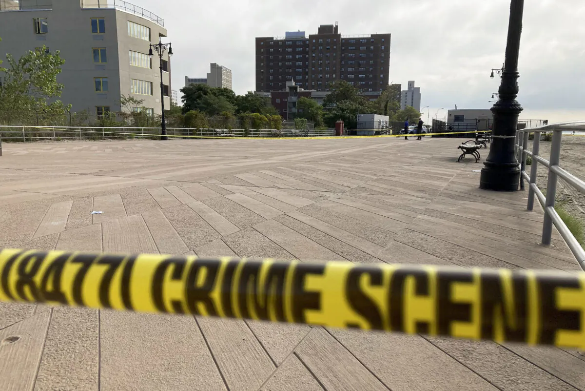 Crime scene tape stretches across a section of the Coney Island boardwalk near a stretch of beach, where three children were found dead in the surf, in New York on Sept. 12, 2022. (Joseph Frederick/AP Photo)