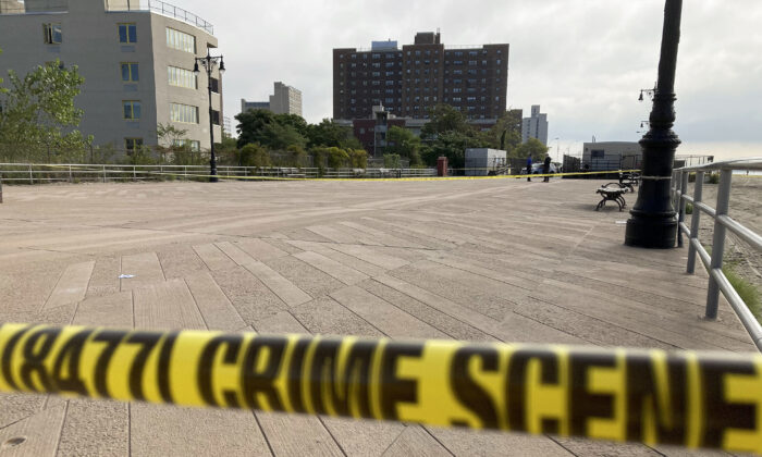 Crime scene tape stretches across a section of the Coney Island boardwalk near a stretch of beach, where three children were found dead in the surf, in New York on Sept. 12, 2022. (Joseph Frederick/AP Photo)