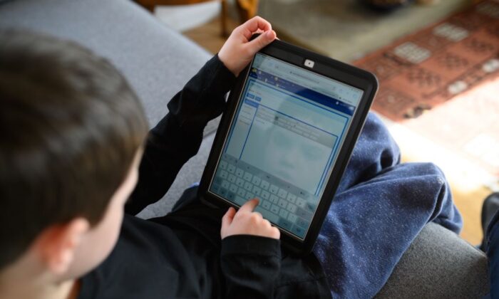 A boy navigates online learning resources provided by his school on March 23, 2020. (Oli Scarff/AFP via Getty Images)