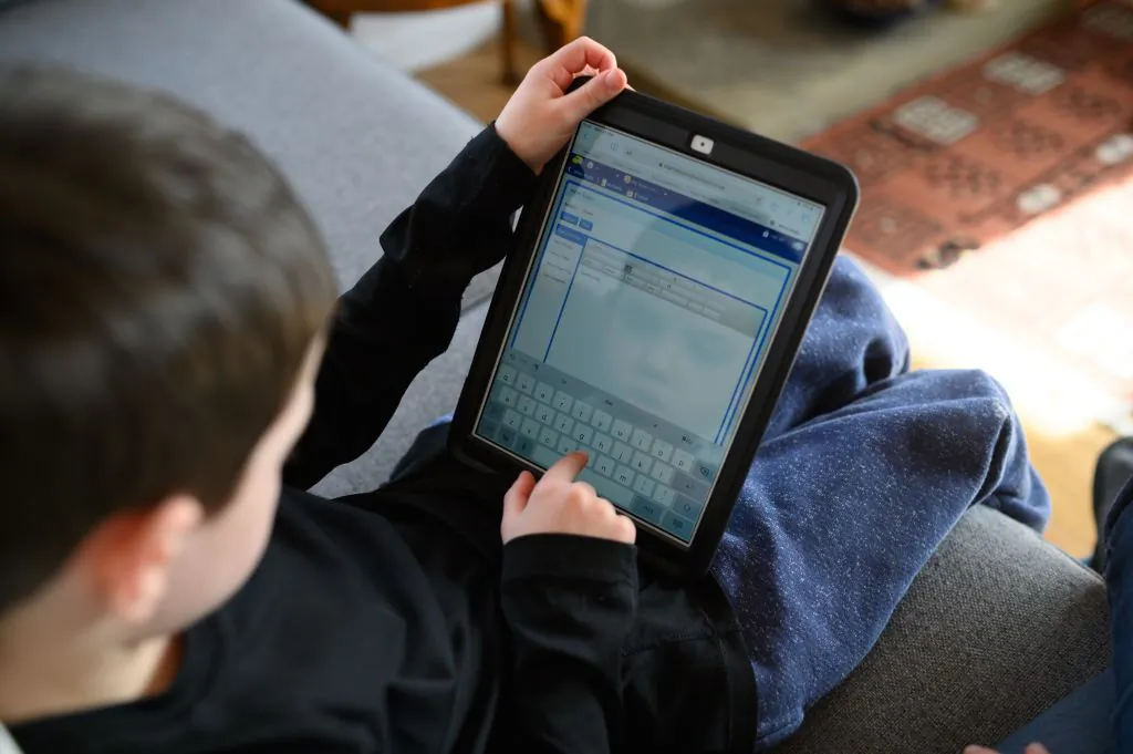 A boy navigates online learning resources provided by his school on March 23, 2020. (Oli Scarff/AFP via Getty Images)