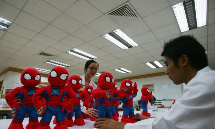 Workers check Spiderman dolls assembled at the production line of Dongguan Da Lang Wealthwise Plastic Factory in Dongguan, China, on Sept. 4, 2007. (Feng Li/Getty Images)