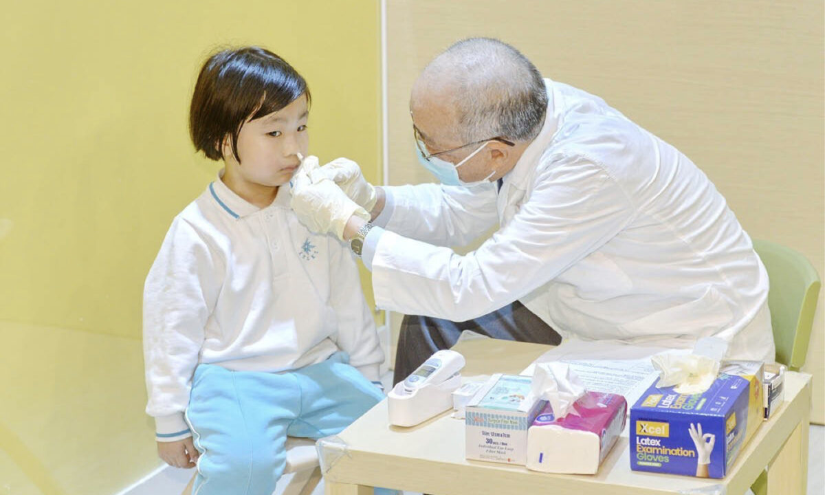 A child receives a flu vaccine via a nasal spray. (Sung Pi-Lung/The Epoch Times)