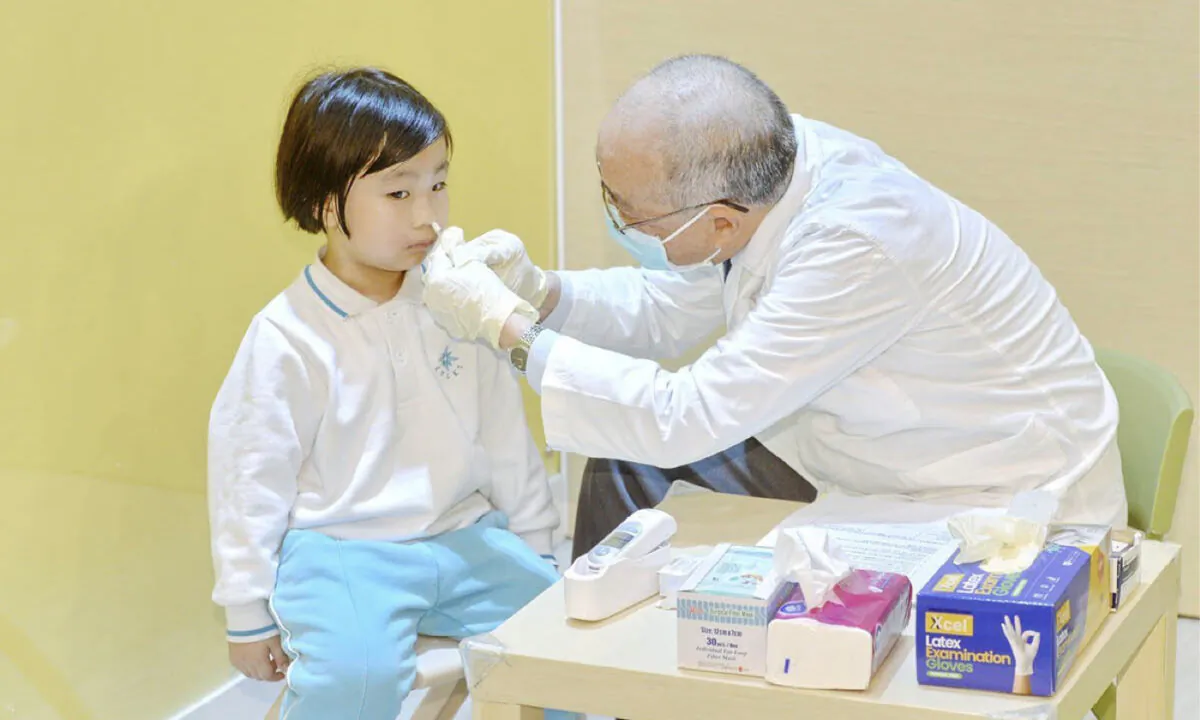 Undated image of a child being squirted with a nasal spray flu vaccine. (Sung Pi-Lung/The Epoch Times)