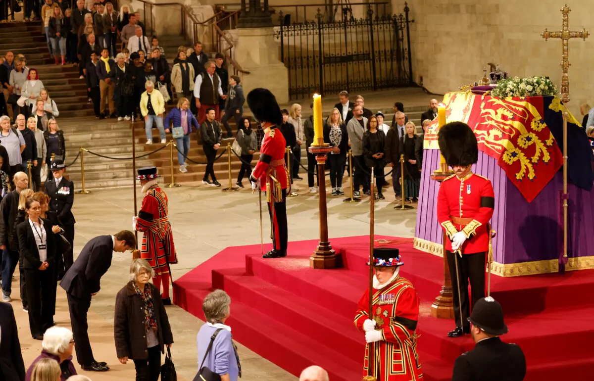 Members of the public file past the coffin of Queen Elizabeth II, draped in the Royal Standard with the Imperial State Crown and the Sovereign's orb and sceptre, in Westminster Hall, London, on Sept. 15, 2022. (Odd Andersen/PA Media)
